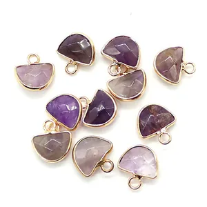 Dettaglio macro di ciondoli in ametista viola sfaccettata a forma di D con placcatura in oro