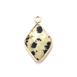 Macro shot of diamond-shaped Dalmatian Jasper pendant with gold-plated edge and ring
