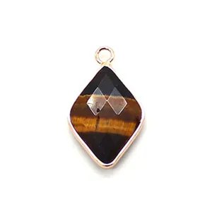 Macro detail of diamond-shaped tiger eye stone pendant with rose gold plated edge