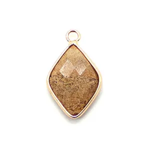 Macro detail of diamond-shaped natural stone pendant with gold plated metal edges