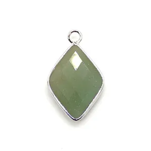 Detail of a faceted green natural stone pendant with silver plated metal edges and ring
