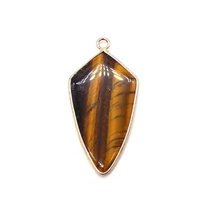 Vue macro du pendentif en œil de tigre avec bord doré et boucle métallique