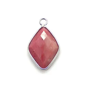 Macro view of faceted pink natural stone pendant with silver plated metal rim