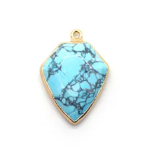 Detail showing shield-shaped turquoise pendant with gold plated edge and spiderweb texture