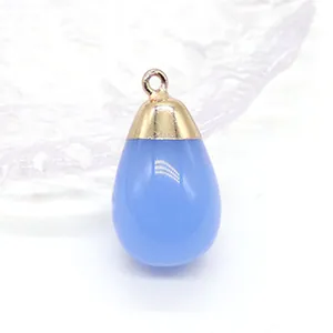 Macro-opname van een hemelsblauwe waterdruppel hanger met gouden kap voor DIY-sieraden