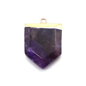 Macro detail of sword-shaped purple amethyst pendant with gold plated metal loop