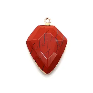 Detailed view of red shield-shaped stone pendant with gold-plated edges for DIY jewelry