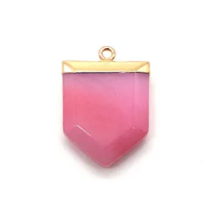 Macro detail of hexagonal sword-shaped pink stone pendant with a gold plated loop