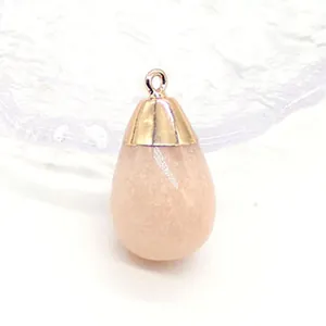 Detail van druppelvormige rozenkwarts hanger met gouden kapje en springring