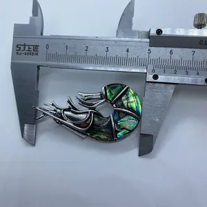 Detailopname van garnalenvormige broche met kleurrijke abalone schelp van 4,5 cm lang