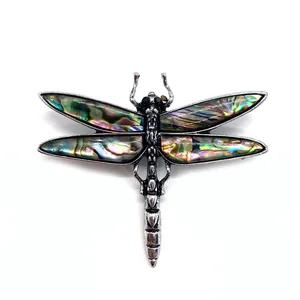 Detailed close-up of dragonfly brooch with iridescent abalone shell wing inlays