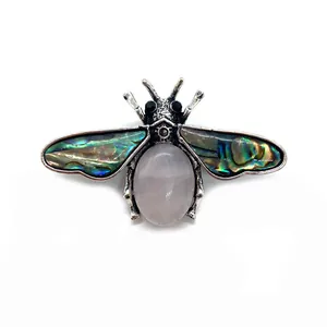 Detailed close-up of bee brooch featuring pink quartz stone and abalone shell wings