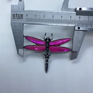 Macro shot showing dragonfly brooch wingspan width measurement of 55mm with a caliper