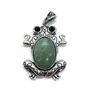 Macro shot of frog pendant with green stone and retro silver floral engraving detail