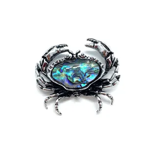 Detail-Makro einer Vintage-Silber-Krabbennadel mit schillernder Abalone-Muschel