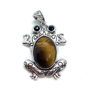 Macro detail of frog pendant with tiger eye stone and vintage silver engraving
