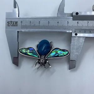 Detailed view of bee brooch with blue stone and abalone shell measuring 5cm wide