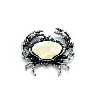 Detailaufnahme einer Vintage Silber-Krabbenbrosche mit eingelegter Naturmuschel