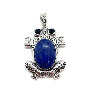 Macro detail of frog pendant with blue stone inlay and vintage silver carvings