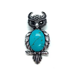 Vintage owl brooch with natural blue stone and silver feather texture on white background