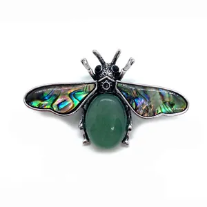 Bee pendant brooch featuring abalone shell wings and oval green stone in vintage metal