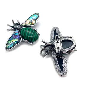 Vintage bee brooch with malachite green stone and rainbow shell wings on silver base