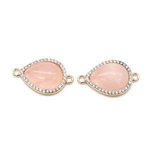 Détail de connecteurs en pierre rose en forme de goutte, plaqué or rose et zircons blancs