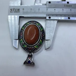 Dettaglio di un ciondolo ovale cloisonné con pietra del sole e smalto floreale da 30mm