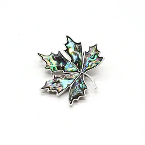Détail d'une broche en forme de feuille d'érable avec nacre d'abalone et bordure argentée
