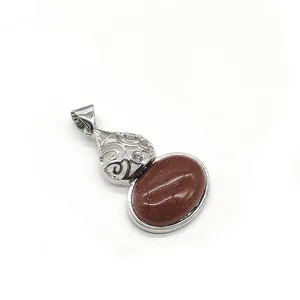 Macro detail of red goldstone pendant featuring vintage filigree metalwork and zircon