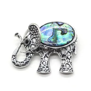 Macro shot of vintage silver elephant brooch featuring colorful abalone shell inlay
