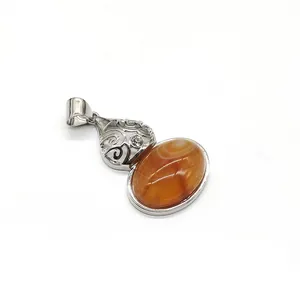 Close-up of agate stone pendant with intricate hollow metalwork and zircon inlay