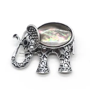 Detailed view of elephant brooch with inlaid shimmering shell and retro silver finish