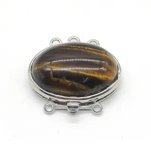 Macro detail of oval tiger eye stone in triple strand zinc alloy jewelry clasp connector