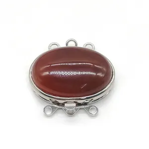 Macro shot of oval red agate stone in silver three-strand clasp for DIY jewelry making