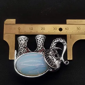 Detailed view of vintage elephant brooch with white stone and measuring caliper