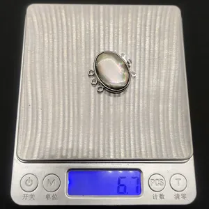 Detail shot of iridescent shell pendant on a scale weighing 6.7g for jewelry DIY