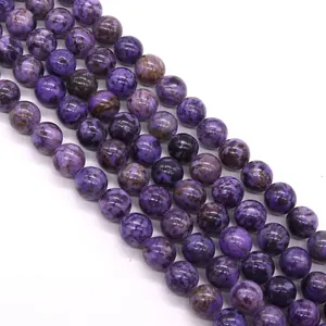Vista macro di perle tonde in pietra naturale viola con trame bianche e nere