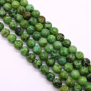 Dettaglio macro di perline rotonde in zoisite verde lucida per la creazione di gioielli