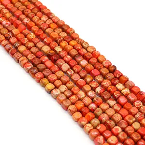 Dettaglio macro di perle a cubo arancioni in pietra per gioielli fai-da-te naturali