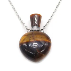 Macro view of heart-shaped tiger eye stone perfume bottle pendant with silver chain