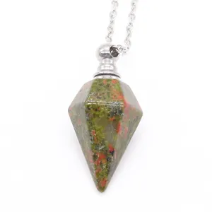 Macro detail of hexagonal Unakite stone pendant on a silver-tone cross chain necklace
