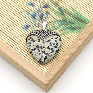 Macro-opname van hartvormige Dalmatische Jaspis hanger met zilveren metalen oogje details