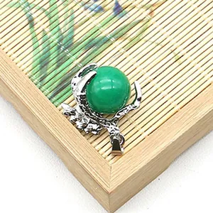 Macro di una gemma verde incastonata in un artiglio di drago d'argento su bambù