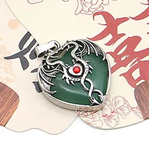 Detailed view of a silver dragon wrapped around a heart-shaped green stone pendant