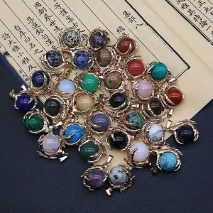 Golden dragon claw pendants with varied natural stone beads on vintage paper