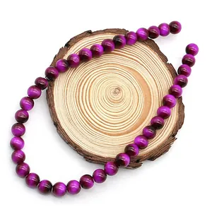 Vista dettagliata di perle tonde occhio di tigre viola da 8mm su supporto in legno