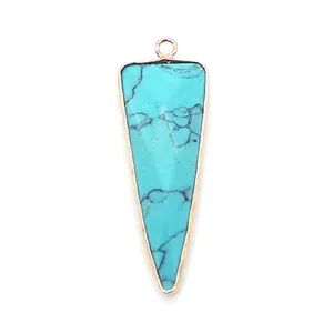 Macro shot of triangular turquoise pendant with gold plated edges and veined texture