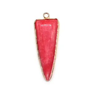 Macro detail of a triangular pink stone pendant with a polished gold metallic border