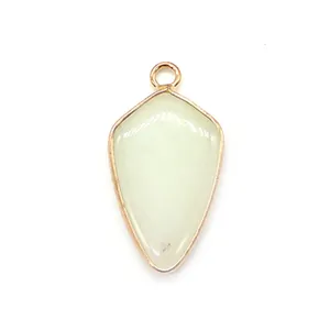 Detailed view of shield-shaped green gemstone pendant with gold-plated metal edging